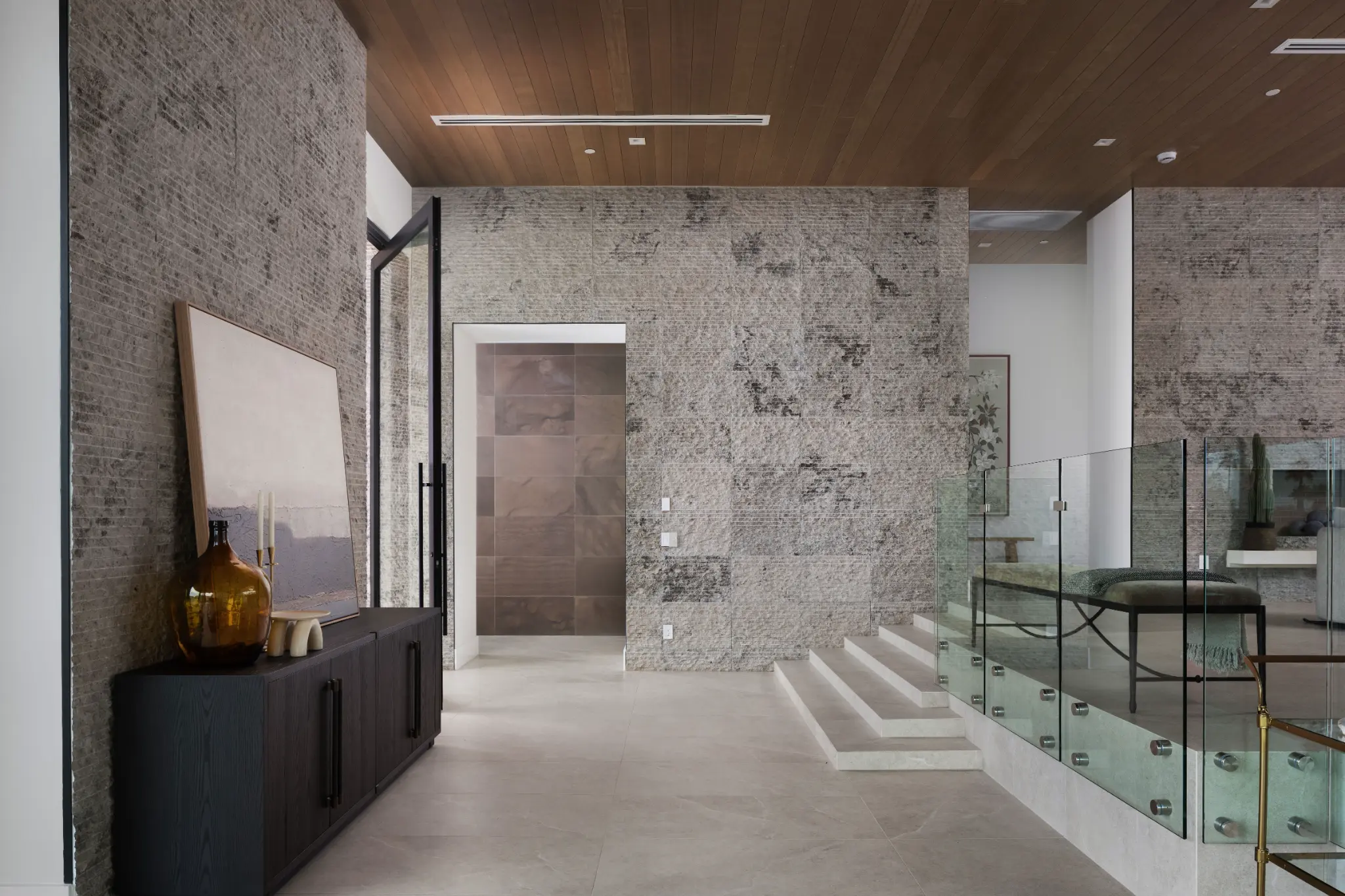Interior entry with stone walls and glass stair at Indian Bend Estate